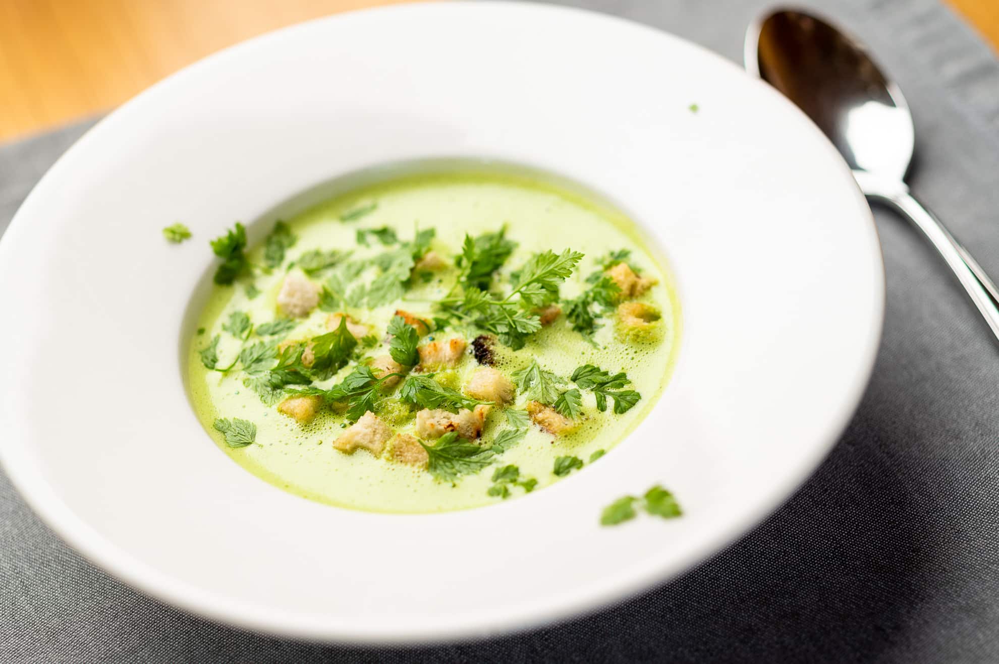 Gourmet-Suppe frisch garniert mit Gemüse & serviert in einem Zürs Restaurant.